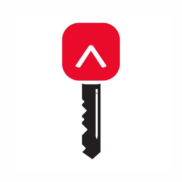 L'image d'une clé noire avec le contour d'un crayon blanc dans la tige. La tête de la clé est le logo « caret » de Réviseurs Canada dans un carré arrondi.